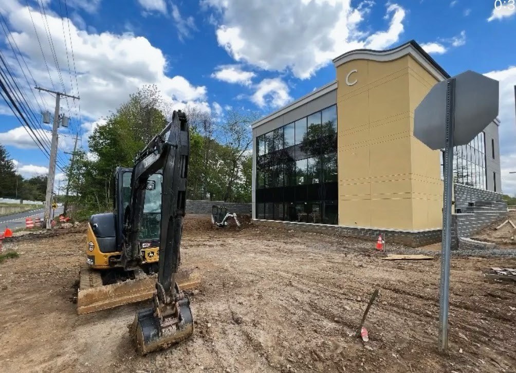 R&R drainage and grading work with equipment at a commercial site